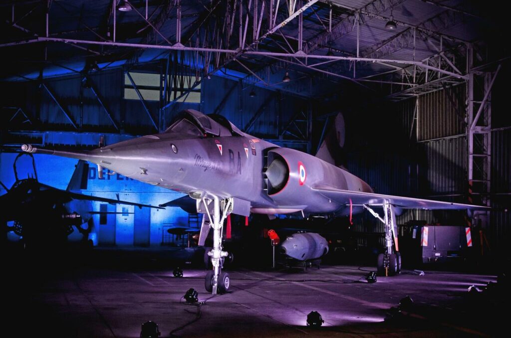 Avion, mirage 4 dans un hangar éclairé par des néons Bleus.